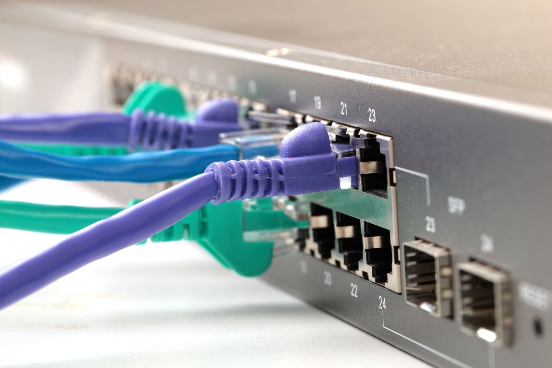 How are QoS standards for fiber optic internet regulated and enforced by governing bodies?